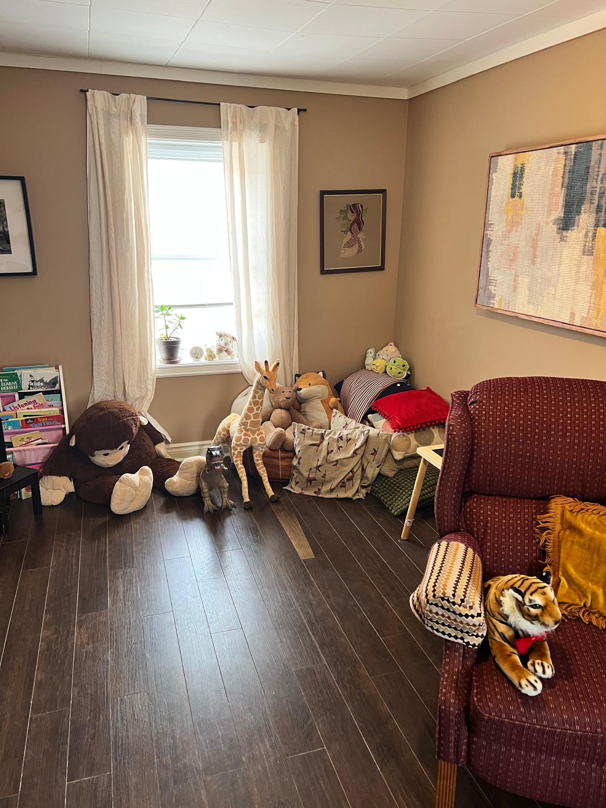 Cozy therapy room with soft seating and stuffed animals